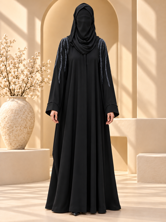 Aabshar Beadwork Shoulder Abaya — front in sunlit courtyard